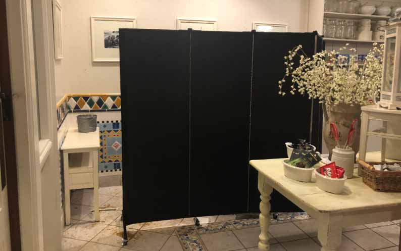 Black portable wall hides water damage in store