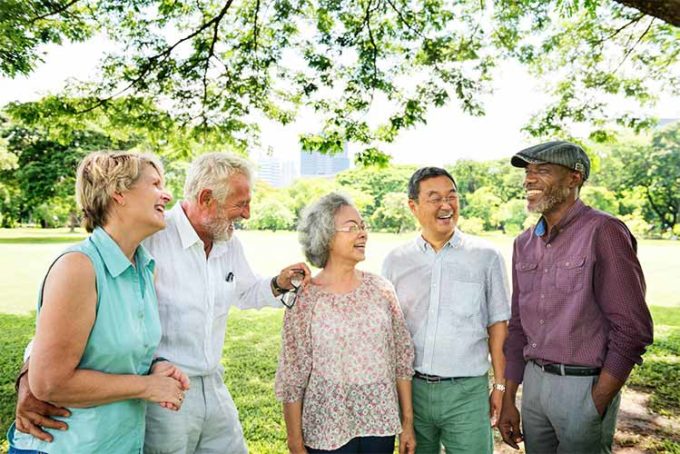 Adults laughing together under the trees