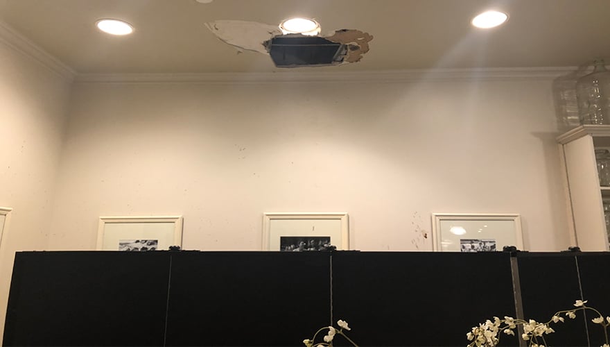 Water damage debris from ceiling hidden behind portable partition