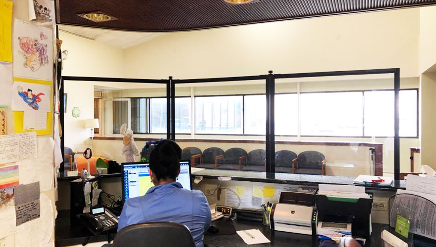 clear-medical-barrier-woman-sitting-behind-at-desk