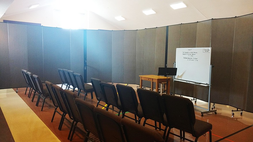 two rows of chairs and whiteboard surrounded by gray room divider