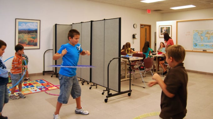 downsizing classrooms kids playing in front of a room divider