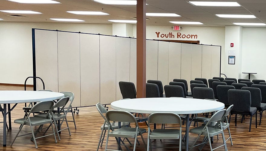 Large fellowship hall with seating furniture in front of a room divider