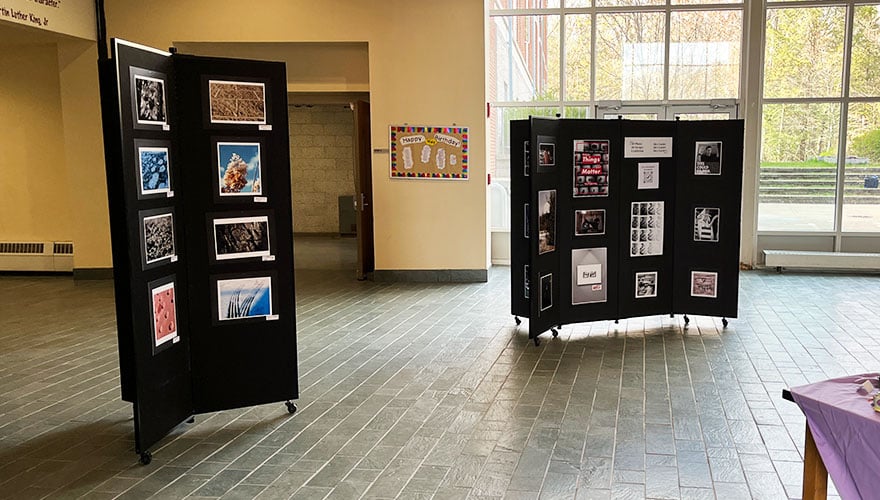 Student art displayed on black panels