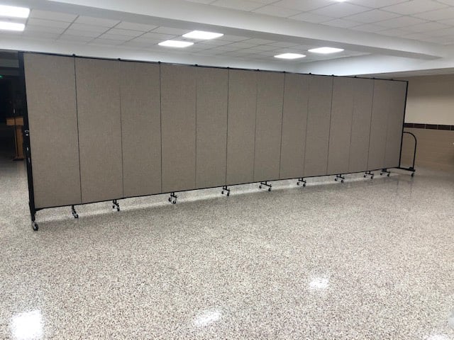 Gray room divider in a large multipurpose room