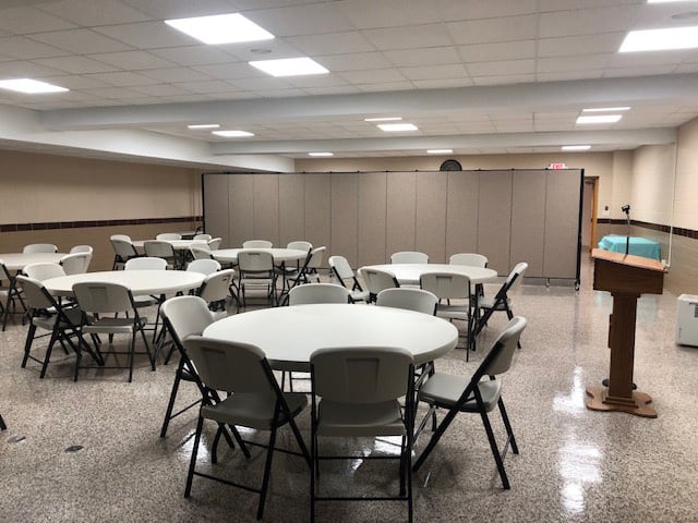 Tables and chairs in front of gray room divider