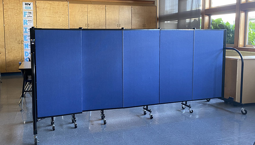 Blue room divider in front of school desks