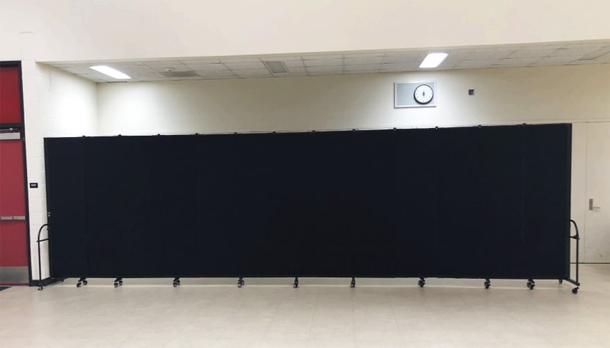 Black room divider opened straight in a large white room