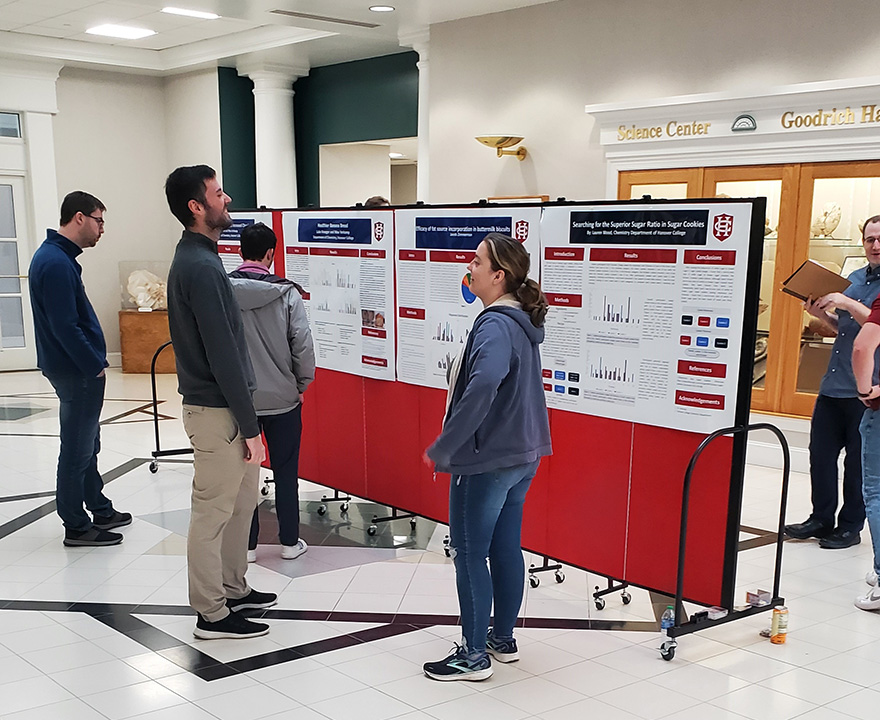 Students standing around a freestanding red bulletin board