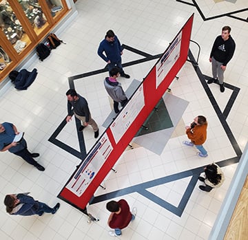 College students looking at a red divider display