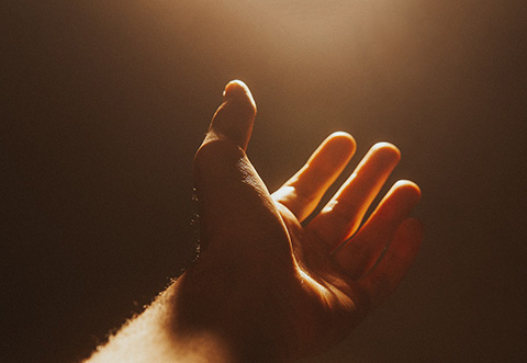 hand reaching towards a golden light