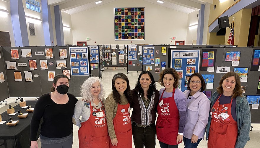 Women standing in front of several art displays